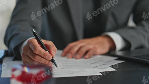 Vista previa: El gerente escribe el informe a mano con un primer plano a bolígrafo. Trabajador ocupado navegando por la computadora
