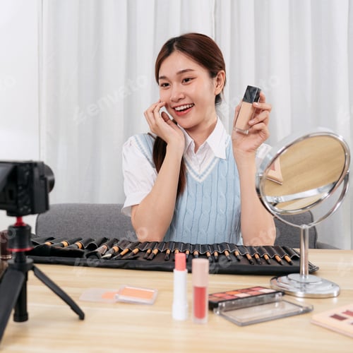 Preview: Young beauty influencer touching face with hand and showing liqu