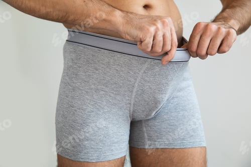 Preview: Young man is looking into his briefs