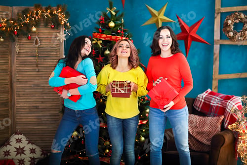 Preview: Smiling happy woman with gift box over living room on Christmas tree background