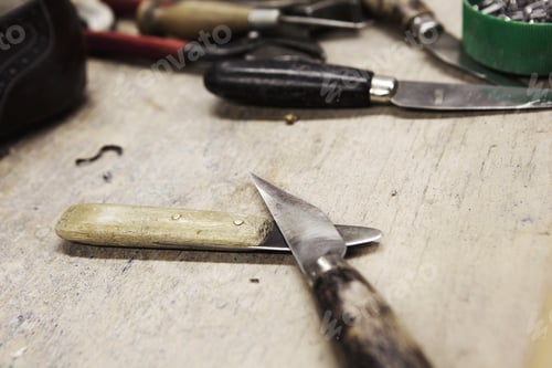 Preview: Close up of knives on bench in shoe makers workshop