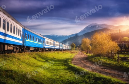 Preview: Moving train in mountains at sunset in autumn. Railway station