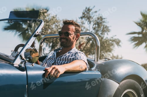 Preview: Man driving a convertible vintage car