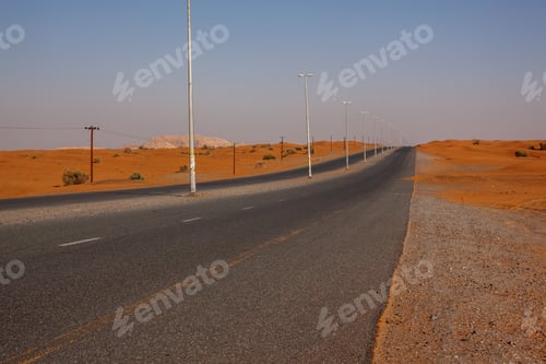 Preview: Winding black asphalt road through sand dunes