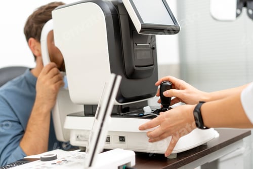 Preview: Young man sitting while having eye sigh analysis in clinic