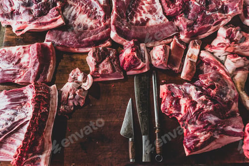 Preview: meat raw assortment and knife on the butcher's dark wooden worki