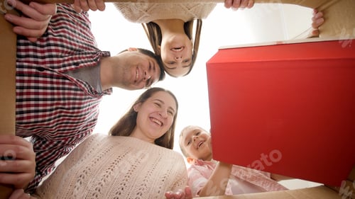 Preview: Happy smiling boy with big family taking out of parcel his birthday or Christmas present. Family