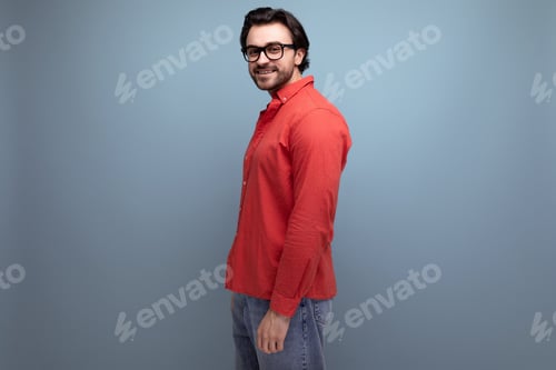 Preview: Smiling Man in Red Shirt Posing by Wall