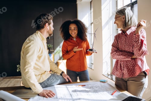 Preview: Engineers discussing wind turbine and solar panel model in office