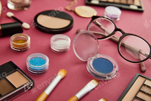 Preview: selective focus of cosmetic brushes near glasses on crimson