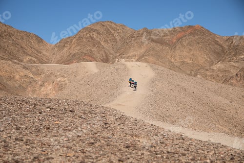 Preview: Hikers Ascending a Sand Dune in Arid Desert