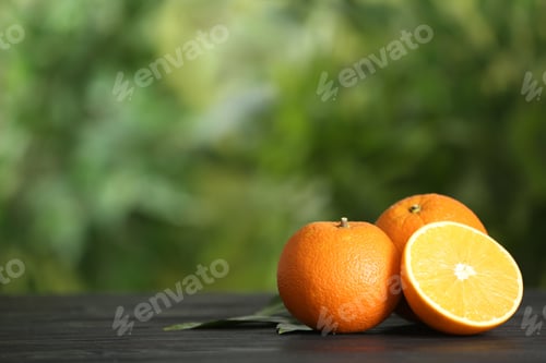 Preview: Fresh ripe oranges on wooden table against blurred background. Space for text