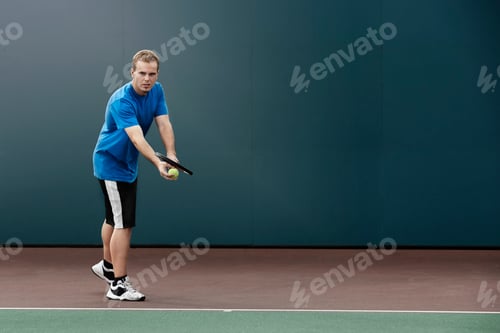 Preview: Tennis player about to serve ball in tennis court