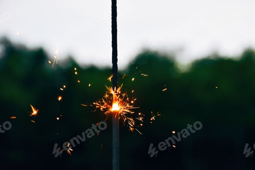 Preview: Sparkler firework burning with blurred background and copy space.
