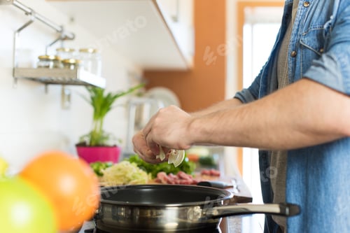 Preview: Man Preparing Food in a Sunny Kitchen