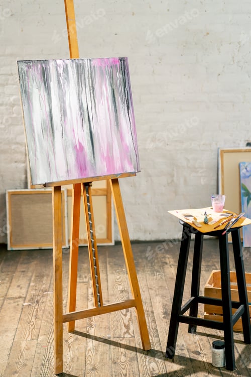 Preview: in the art workshop there is a tripod with a finished painting next to stool on there is a palette