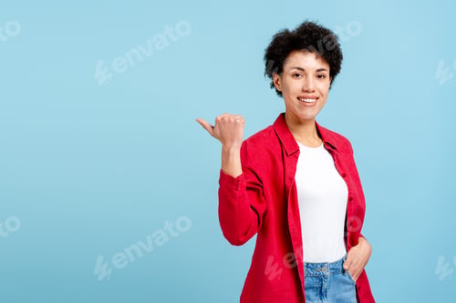 Preview: Happy woman pointing thumb left, indicating direction on blue background