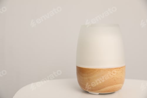 Preview: Modern aroma lamp on white table indoors. Space for text