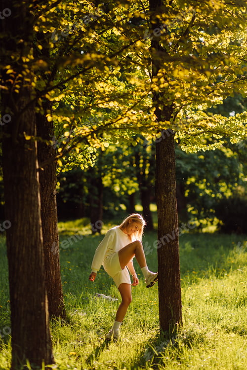 Preview: Young blonde girl is wearing a white hoodie smiling and walking in the woods