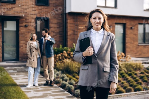 Preview: Beautiful woman, real estate agent smiling while couple buys new home