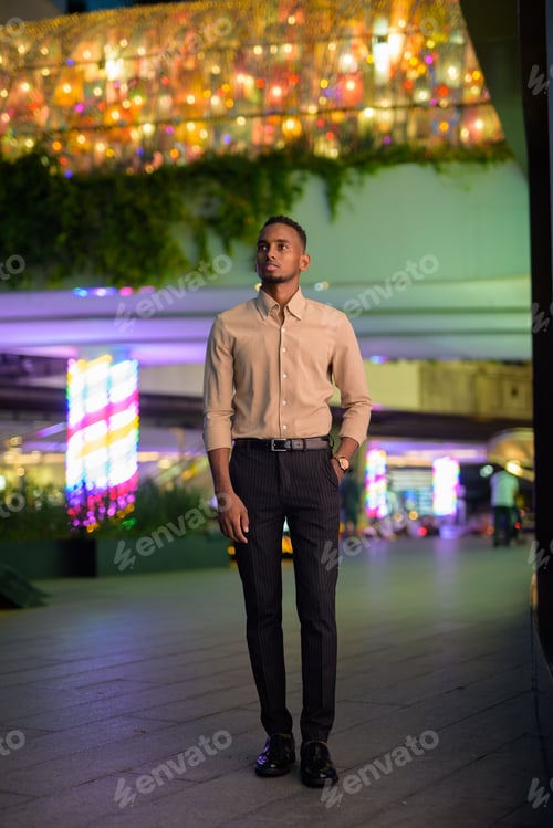 Preview: Full length shot of African businessman outdoors in city thinking