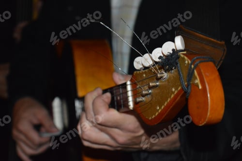 Preview: Closeup of man’s hands playing string instrument