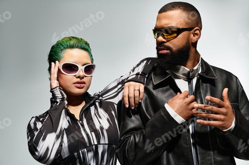 Preview: Stylish multicultural couple showcases trendy outfits in studio setting