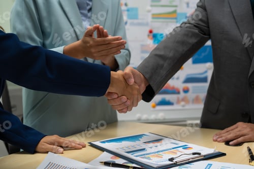 Preview: A businessperson, holding hands, cooperate during a corporate meeting. review a graph document