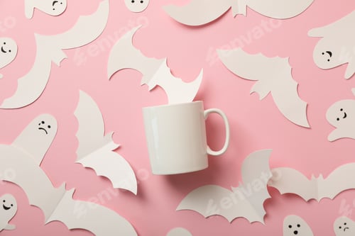 Preview: Paper ghosts and bats, cup on pink background, top view