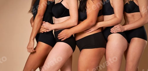 Preview: Side view of four unrecognizable women in black underwear standing in a row