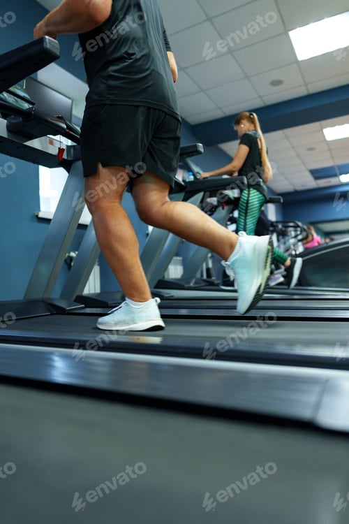 Preview: Fit man running on treadmill in a gym
