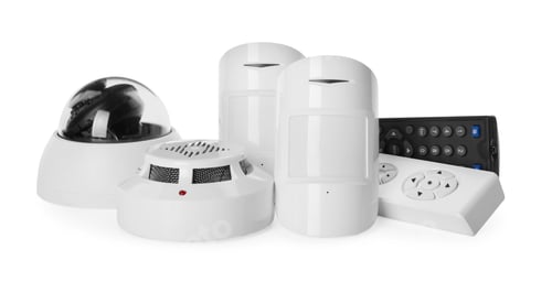 Preview: CCTV camera, remote controls, smoke and movement detectors on white background. Home security system