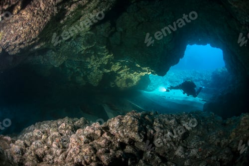 Preview: Silhouetted Scuba Diver Enters an Underwater Cavern
