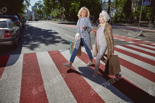 Preview: Two cheerful women laughing and going down the city street