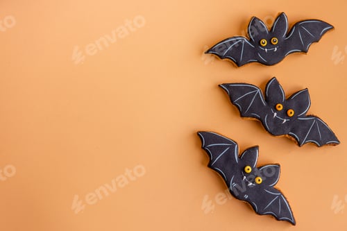 Preview: Holiday card for Halloween. Black bats, hand made gingerbread cookies isolated on orange background