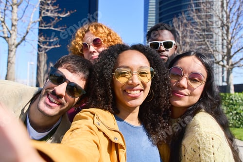 Preview: Happy multi ethnic friends taking selfie outdoors in the city