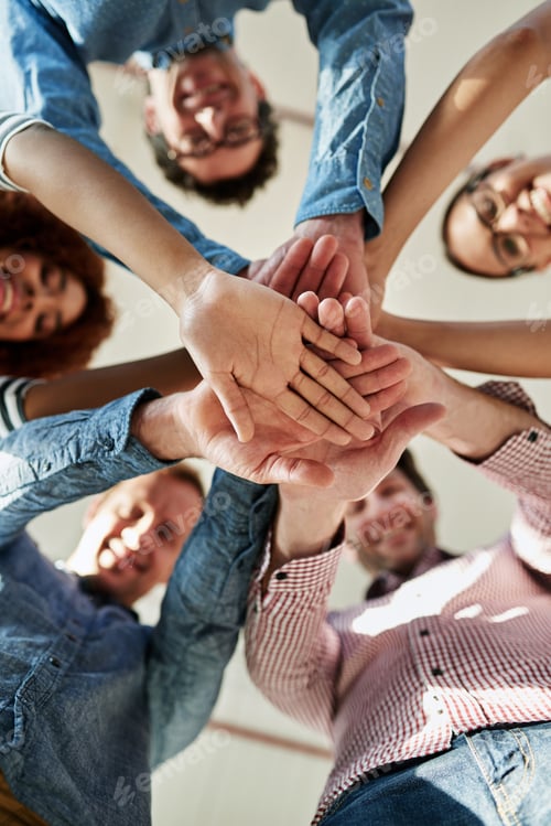 Preview: In it to succeed. Low angle portrait of a group of smiling coworkers in a huddle.