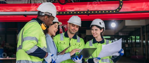 Preview: A group of construction workers are smiling and looking at a piece of paper