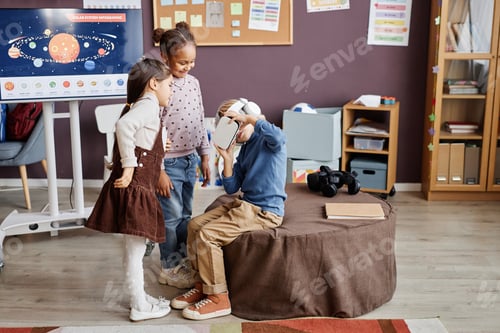 Preview: Two intercultural little girls standing in front of boy in vr headset