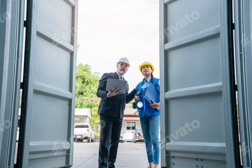 Preview: Container yard manager with safety hat talking to foreman about the goods inside the warehouse.