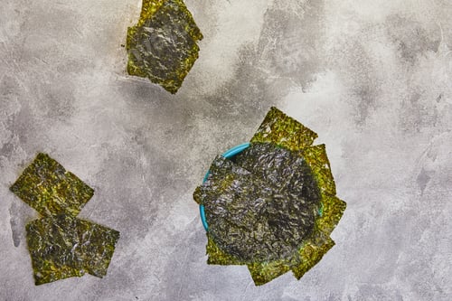 Preview: Crispy nori seaweed in a blue bowl on a gray background. Japanese food nori.