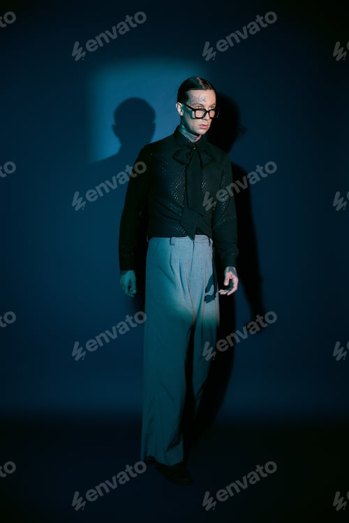 Preview: Handsome young man embodies modern elegance in stylish attire against a captivating blue backdrop