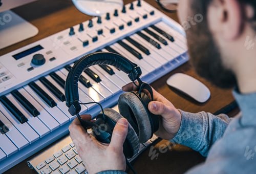 Preview: Musician with Headphones at Music Mixing Equipment