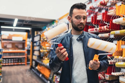 Preview: a buyer in a hardware store chooses rollers for painting work.