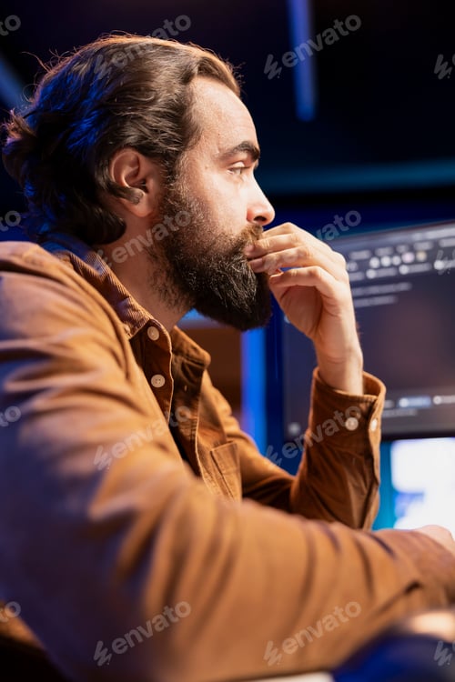 Preview: Programmer carefully reading lines of code on desktop PC monitor