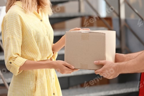 Preview: Woman receiving parcel from deliveryman on blurred background, closeup. Space for text