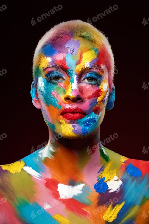 Preview: Studio shot of a young woman posing with multi-coloured paint on her face
