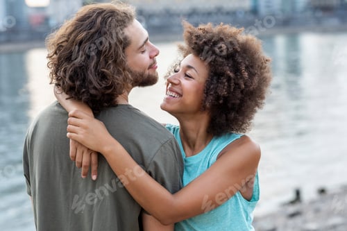 Preview: Happy young couple hugging at the riverside