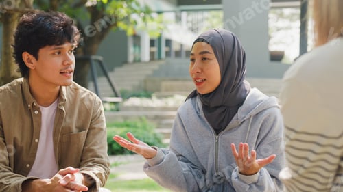 Preview: Small Asian group of people sit in a close circle and talk to a therapist in park.