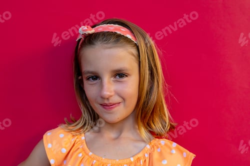 Preview: Portrait of happy caucasian schoolgirl with band over pink background at elementary school